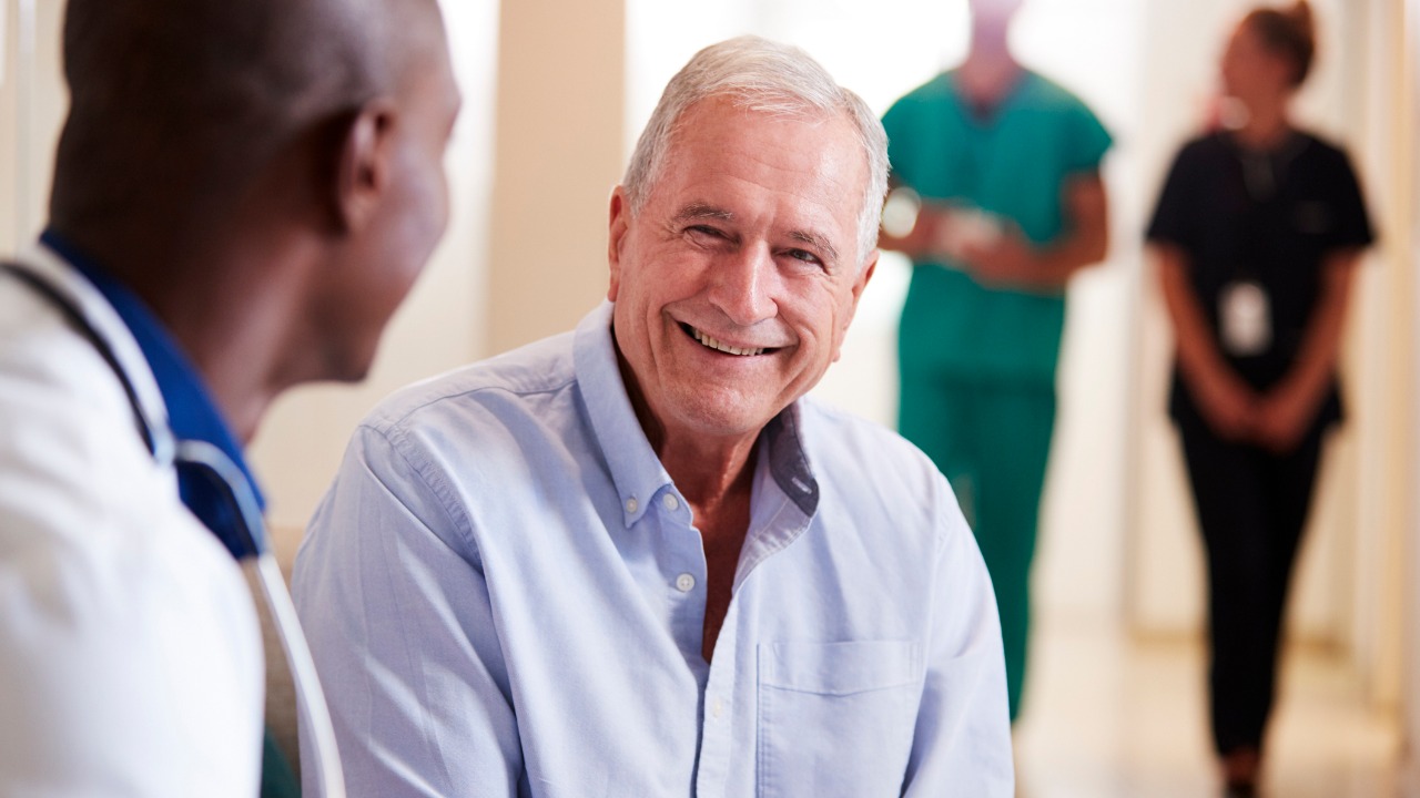 doctor-welcoming-to-senior-male-patient-being-admitted-to-hospital-picture-id1147980079